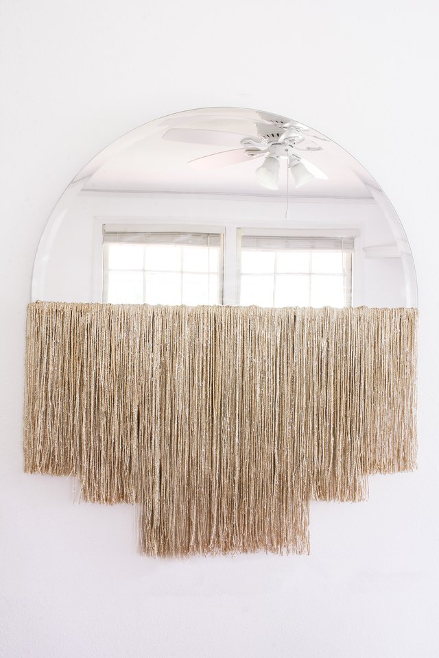 DIY fringe mirror hanging on wall