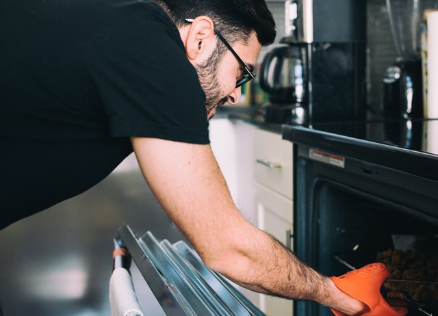 Man removing food from oven