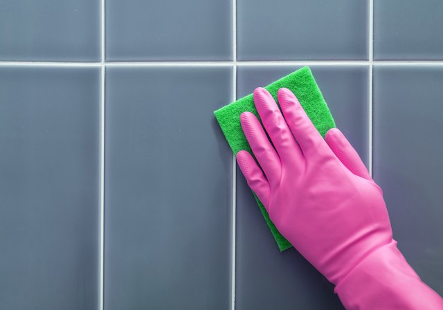 Hand washes the tile.