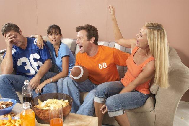 Two couples watching football in living room