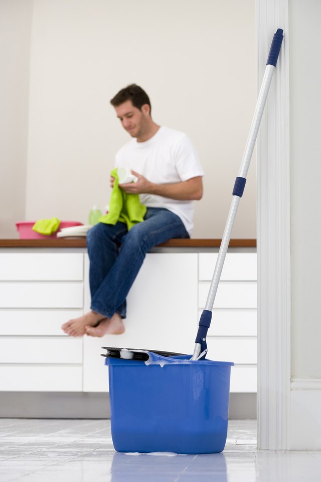 How To Use Ammonia Clean Laminate Floors Hunker Man Sitting On Kitchen Counter With Mop And Bucket