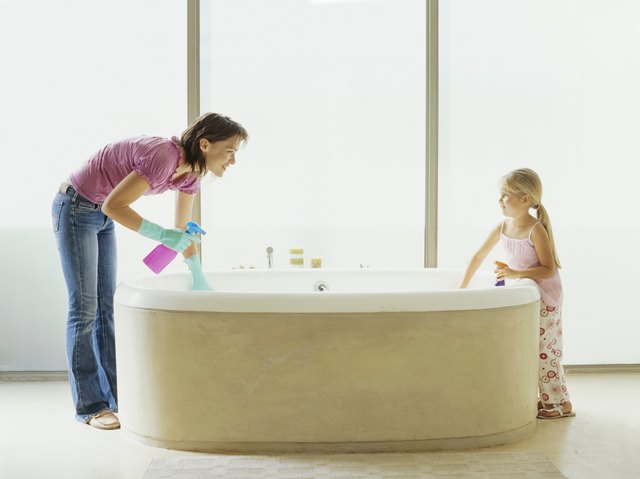 Side profile of mother and her daughter washing the bathtub
