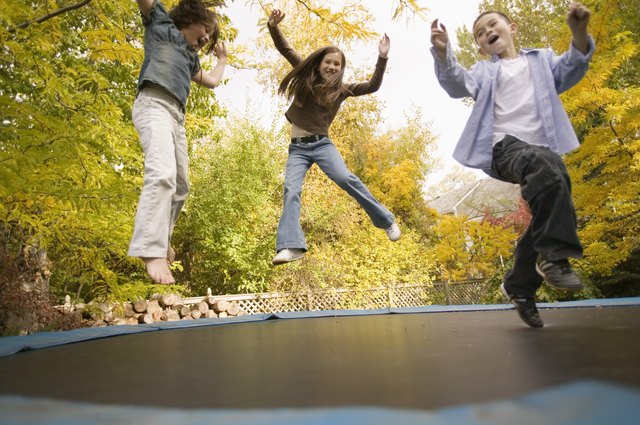Siblings jumping on trampoline