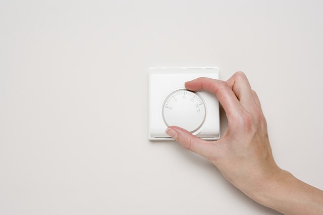 Person turning thermostat