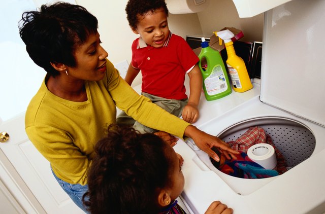 Mother Teaching Her Children How To Do Laundry