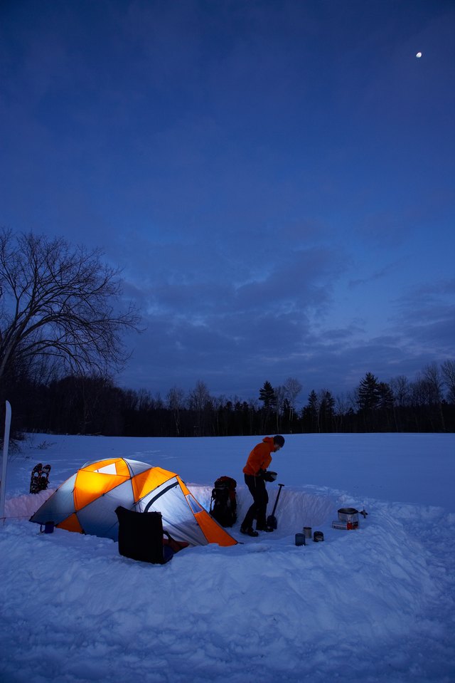 Illuminated tent and person at night in winter