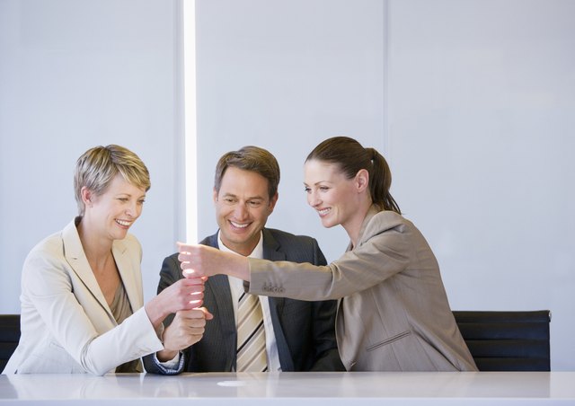 Business people holding glowing light in conference room