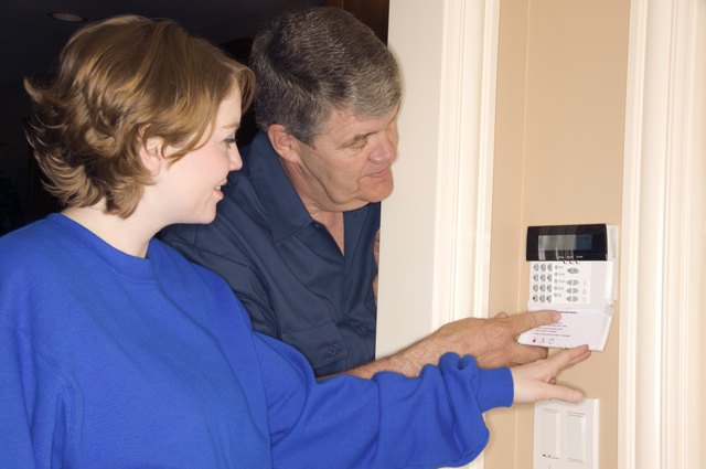 Man and woman setting home alarm system