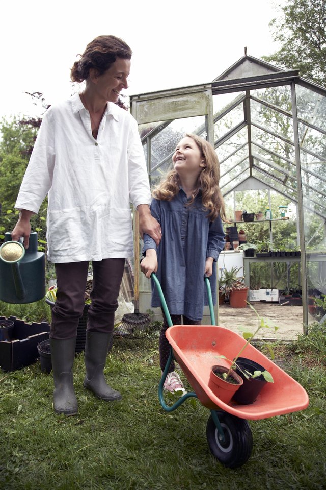 mother and girl in garden with wheelbarrow