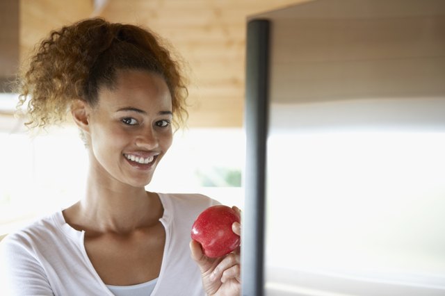 Mixed Race woman holding apple