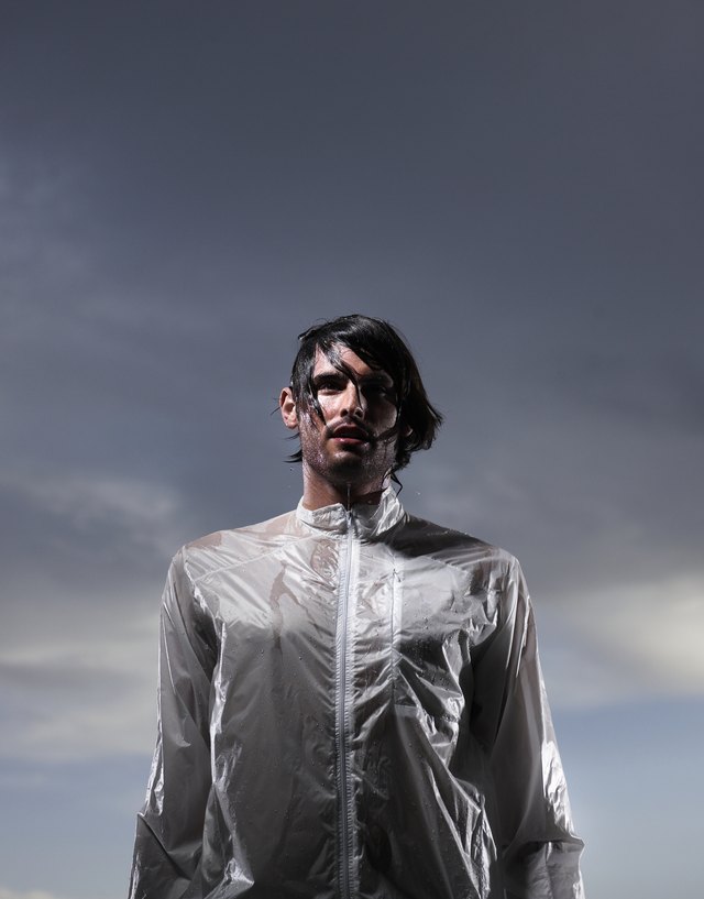 Drenched young man at dusk, low angle view