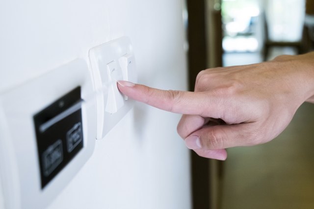 hand with finger on light switch