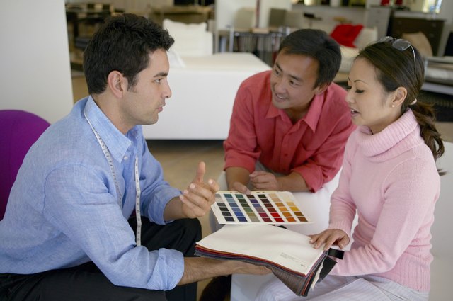 Couple Discuss Fabric Swatches and Colour Charts With an Assistant in an Interiors Shop