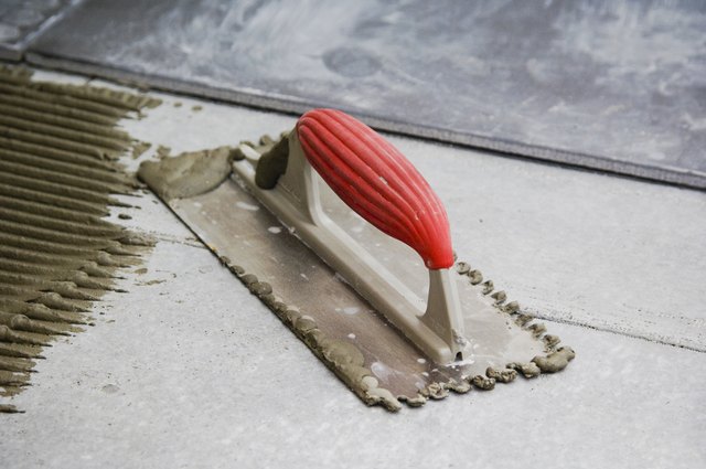 Mortar, trowel and tile on subfloor