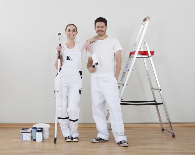 Young Couple Holding Paint Roller