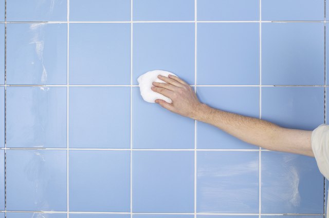 Hand holding cloth to wall