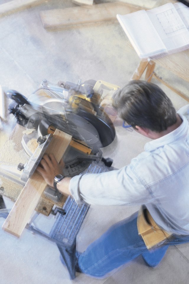 Construction worker using a miter saw