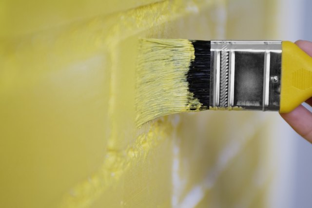 Person painting the wall yellow
