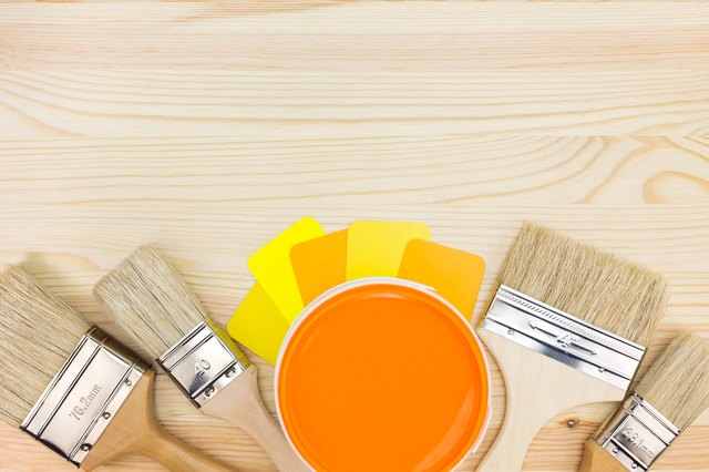 brushes, color guide and paint can on wooden background