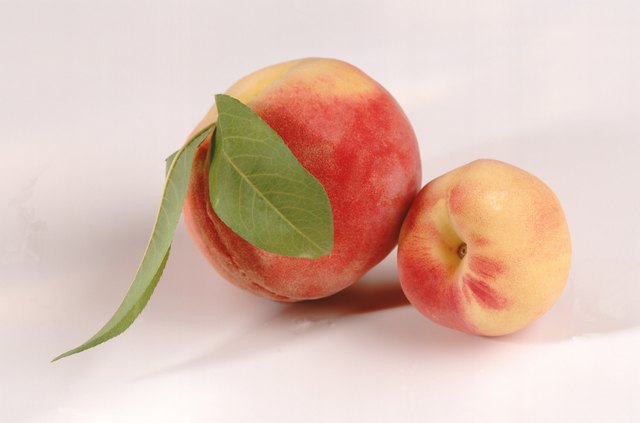 Peach with lead on white background, close-up