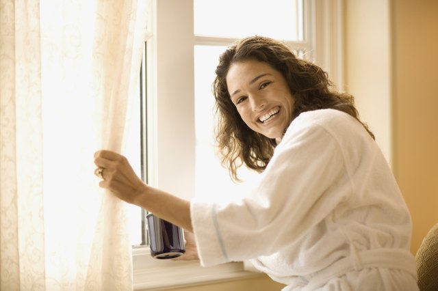 Woman with coffee near window