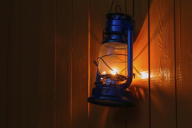 old kerosene lantern hanging on the yellow wooden wall