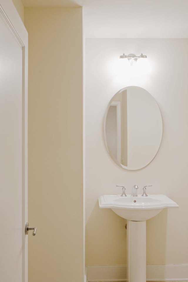 Pedestal sink and mirror in bathroom