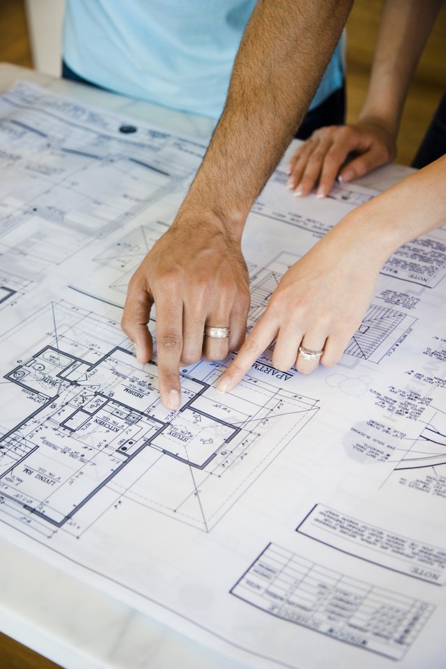 Couple pointing to blueprints