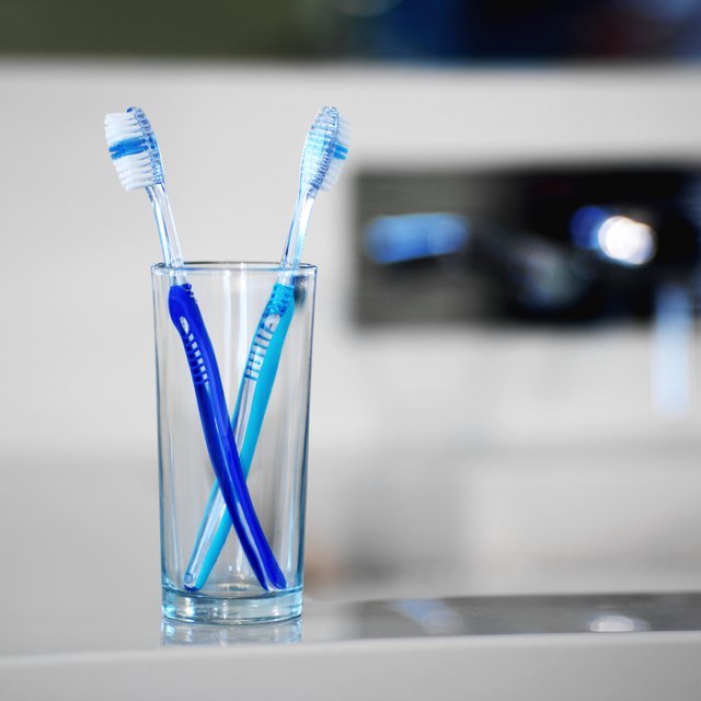 close up view of two toothbrushes in a glass