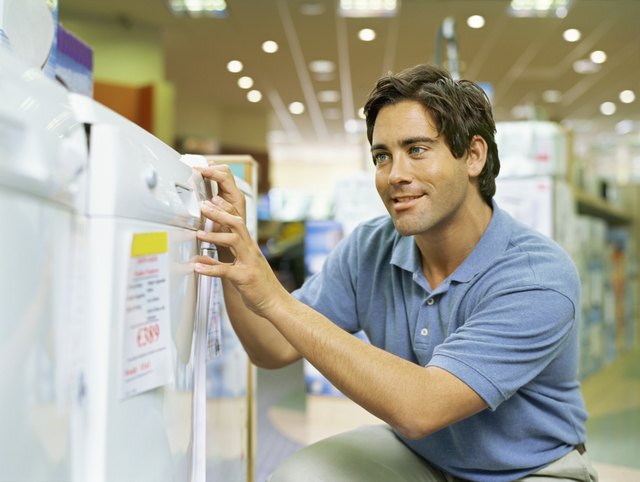 close-up of a young man looking at a refrigerator in an electronics store