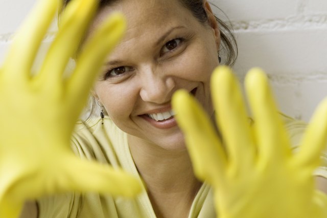 Woman with rubber gloves hands in front of face, close-up