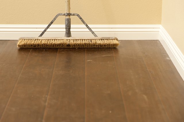 Push Broom on Newly Installed Dusty Laminate Floor and Baseboard