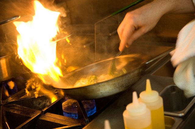 Chef cooking with a flaming pan.