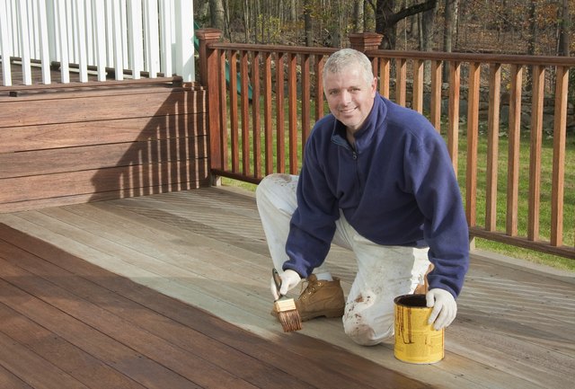 painter or handyman staining a deck