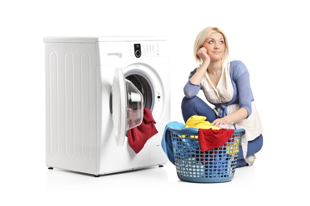 Woman in thoughts seated next to a washing machine