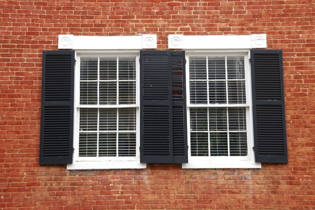 Windows with Black Shutters on Red Brick House