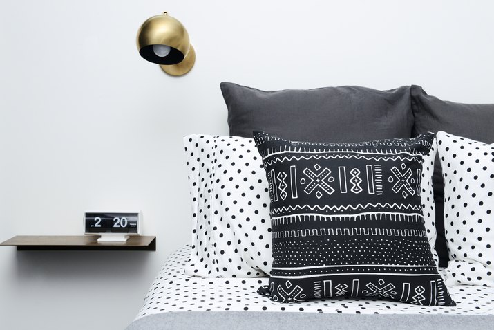 black and white bedding with gold sconce