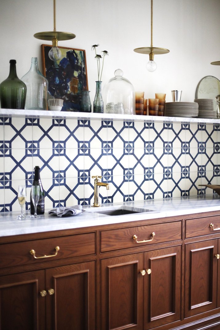 kitchen with blue backsplash and marble counters