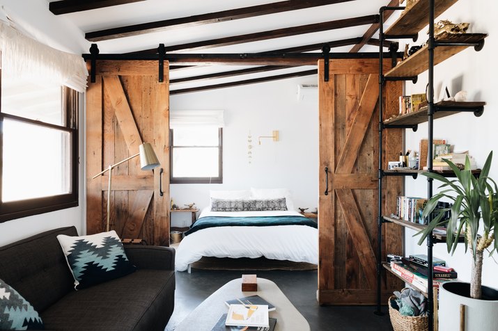 rustic modern cabin bedroom with barn doors and exposed ceiling beams