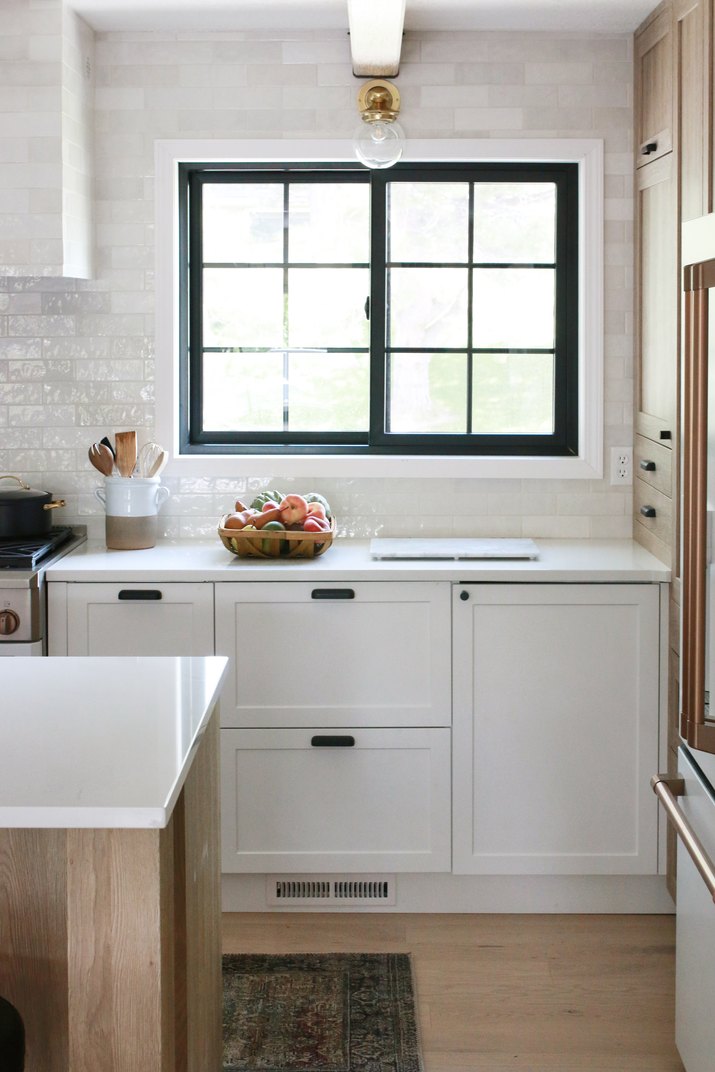kitchen with white subway tile backsplash and black framed windows