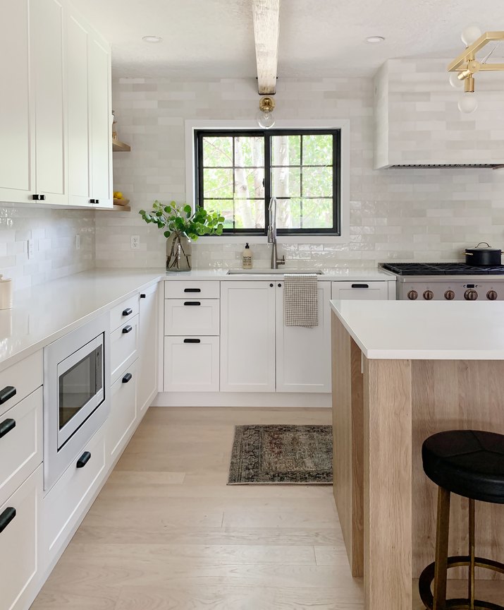 kitchen with white subway tile backsplash and white cabinetry